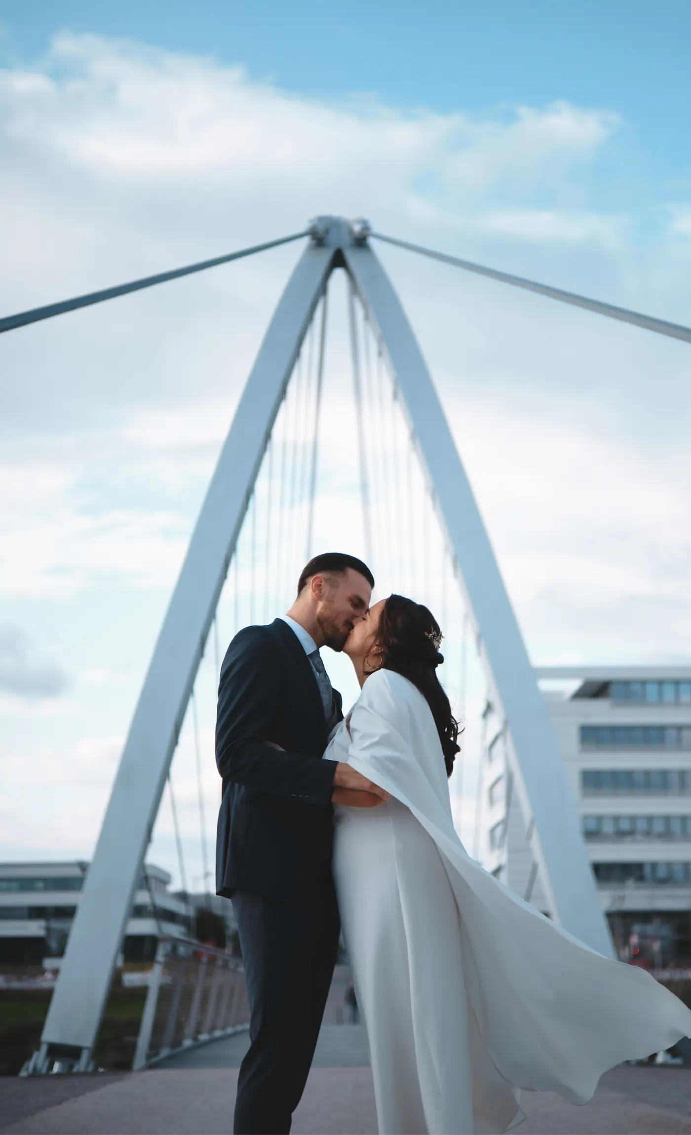 Hochzeitspaar das sich auf einer Brücke küsst